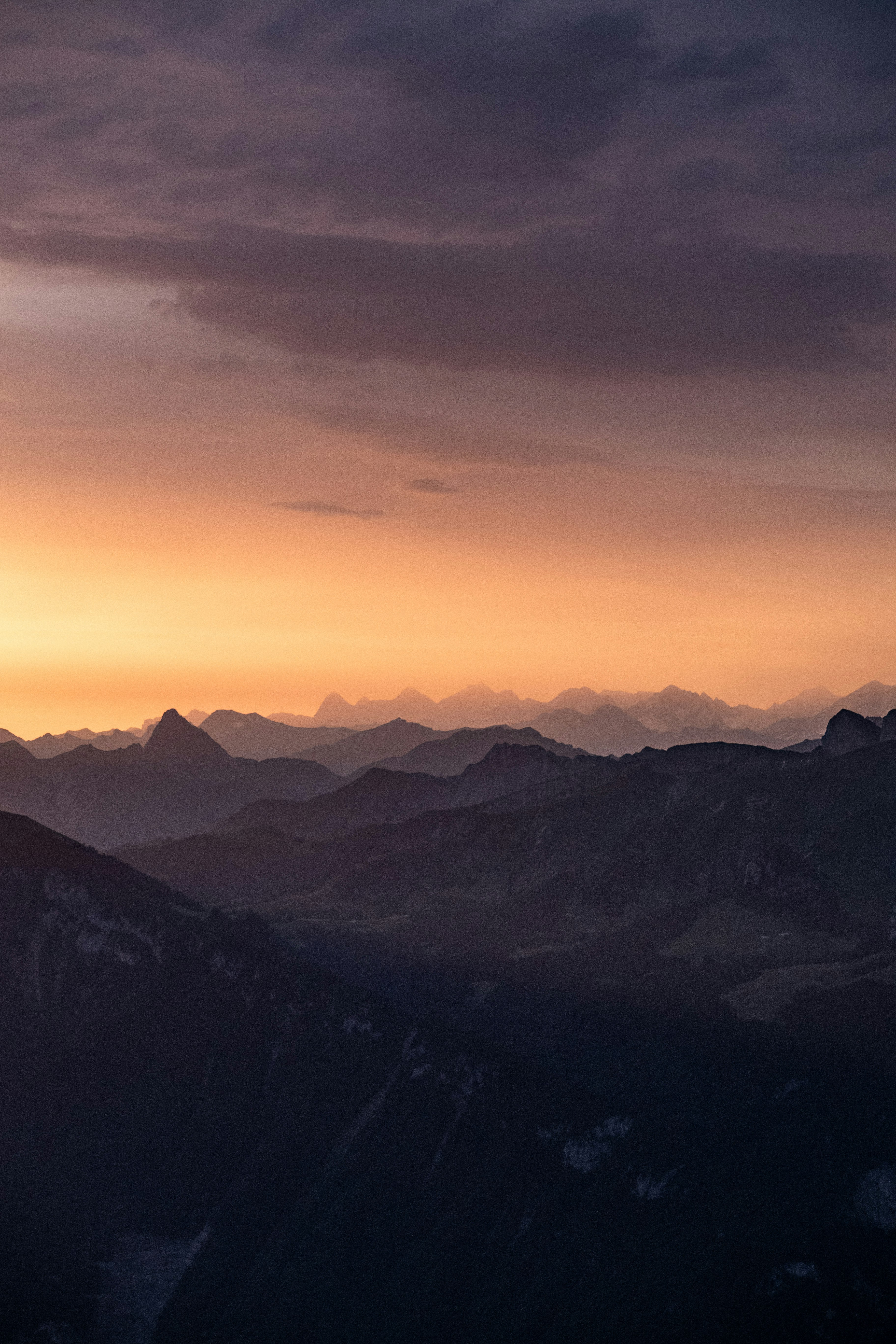 black and white mountains under orange sky